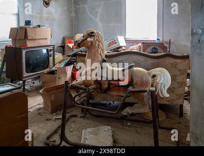 Un vieux cheval de loisir et d'autres reliques sont trouvés dans une maison abandonnée Banque D'Images