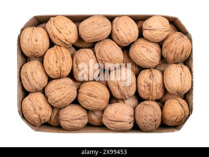 Noix dans leurs coquilles, dans une barquette en carton. Graines séchées non décortiquées du noyer commun Juglans regia. Noix entières avec coquille, utilisées comme snac etc Banque D'Images