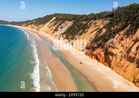 Vue aérienne une plage étroite sous de hautes falaises colorées à Rainbow Beach sur la Sunshine Coast du Queensland, en Australie Banque D'Images