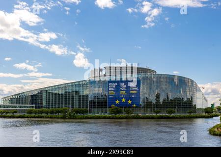 Europaparlament in Straßburg vor der Europawahl Das Sitzungsgebäude des Europäischen Parlaments in Straßburg : für die bevorstehende Europawahl 2024 wurde ein überdimensionales, mehrsprachiges Plakat mit dem Aufruf zur Stimmabgabe angebracht. Straßburg ist der zweite Sitz des eu-Parlaments neben Brüssel. Straßburg Robertsau Sud Ouest Bas-Rhin Frankreich *** Parlement européen à Strasbourg avant les élections européennes bâtiment du Parlement européen à Strasbourg une affiche multilingue surdimensionnée avec appel au vote a été mise en place pour les prochaines élections européennes de 2024 Strasbourg IS Banque D'Images