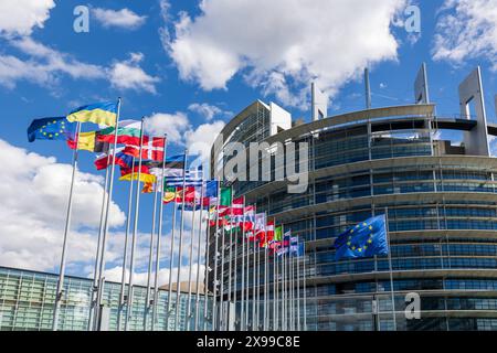 Europaparlament in Straßburg vor der Europawahl Die Flaggen der europäischen Mitgliedsstaaten vor dem Europaparlamentsgebäude, ergänzt durch die Flagge der Europäischen Union und aus Solidarität mit der Ukraine auch die Ukraineflagge neben der eu-Flagge. Straßburg Contades Nord Bas-Rhin Frankreich *** Parlement européen à Strasbourg avant les élections européennes les drapeaux des états membres européens devant le bâtiment du Parlement européen, complétés par le drapeau de l'Union européenne et, en solidarité avec l'Ukraine, le drapeau de l'Ukraine à côté du drapeau de l'UE Strasbourg Contades Nord Bas R. Banque D'Images