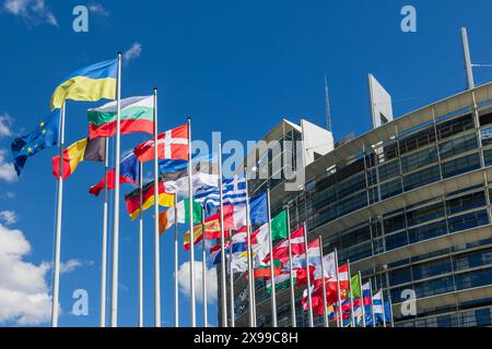 Europaparlament in Straßburg vor der Europawahl Die Flaggen der europäischen Mitgliedsstaaten vor dem Europaparlamentsgebäude, ergänzt durch die Flagge der Europäischen Union und aus Solidarität mit der Ukraine auch die Ukraineflagge neben der eu-Flagge. Straßburg Contades Nord Bas-Rhin Frankreich *** Parlement européen à Strasbourg avant les élections européennes les drapeaux des états membres européens devant le bâtiment du Parlement européen, complétés par le drapeau de l'Union européenne et, en solidarité avec l'Ukraine, le drapeau de l'Ukraine à côté du drapeau de l'UE Strasbourg Contades Nord Bas R. Banque D'Images