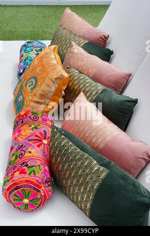 Coussins décoratifs sur un lit lounge, éléments de décoration intérieure aux motifs audacieux, détails brodés et tissus luxueux Banque D'Images