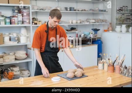 Potter pétrit l'argile avant de l'utiliser dans l'atelier. Banque D'Images