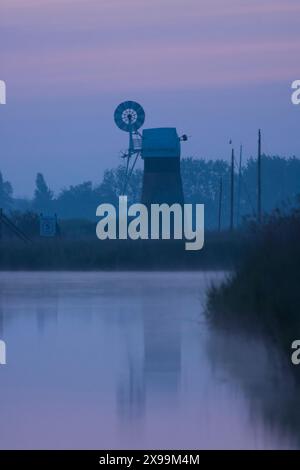 Usine de drainage de niveau de St Benet, brume bleue au crépuscule, vue de la rivière Bure, Banque D'Images