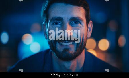Portrait de bel homme passant du temps à la maison, se reposant sur un canapé, changer les chaînes sur la télévision avec télécommande dans élégant appartement loft. Jeune homme se tourne vers le service de streaming de film et se détendre. Banque D'Images