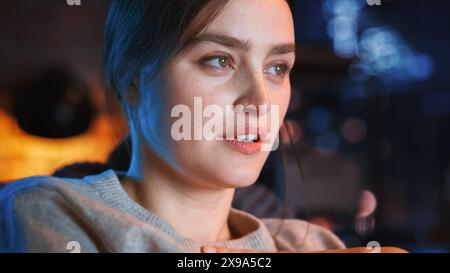 Portrait de belle femme inquiète passer du temps à la maison, se reposer sur un canapé, regarder Thriller TV Show dans un élégant appartement loft. Jeune femme profiter de regarder Scary Movie seul sur le service de streaming. Banque D'Images