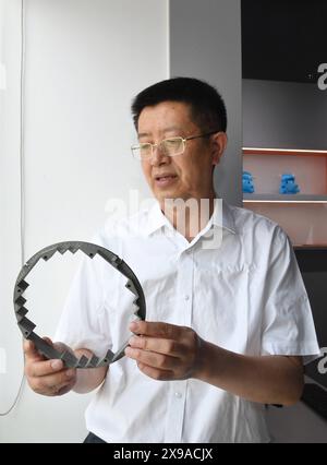 (240530) -- CHENGDU, 30 mai 2024 (Xinhua) -- Zhong Yuanzhang montre une pièce de réacteur nucléaire imprimée en 3D à l'Institut chinois de l'énergie nucléaire à Chengdu, dans la province du Sichuan, au sud-ouest de la Chine, le 24 mai 2024. Zhong était le concepteur en chef adjoint du projet d'énergie nucléaire Hualong de l'Institut de l'énergie nucléaire de Chine. Depuis qu'il a obtenu son diplôme de l'Université des sciences et de la technologie de Chengdu (aujourd'hui Université du Sichuan) avec spécialisation en génie chimique en 1986, Zhong a participé à la conception de structures de réacteurs et à la R&d de plus de la moitié des centrales nucléaires chinoises. (Xinhua/Liu Kun) Banque D'Images