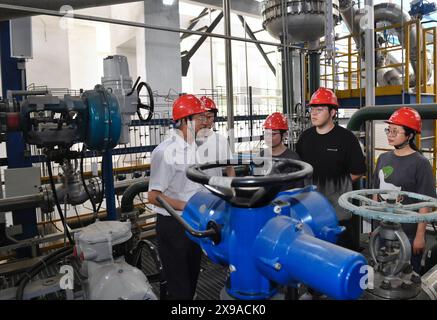 (240530) -- CHENGDU, 30 mai 2024 (Xinhua) -- Zhong Yuanzhang (1er l) communique avec des collègues sur une plate-forme expérimentale à l'Institut de l'énergie nucléaire de Chine à Chengdu, dans la province du Sichuan du sud-ouest de la Chine, le 24 mai 2024. Zhong était le concepteur en chef adjoint du projet d'énergie nucléaire Hualong de l'Institut de l'énergie nucléaire de Chine. Depuis qu'il a obtenu son diplôme de l'Université des sciences et de la technologie de Chengdu (aujourd'hui Université du Sichuan) avec spécialisation en génie chimique en 1986, Zhong s'est engagé dans la conception de structures de réacteurs et a participé à la R&d de plus de la moitié de la puissance nucléaire chinoise Banque D'Images