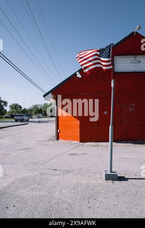 Bâtiment rouge et un drapeau américain sur un poteau, à Lexington Heights Michigan USA Banque D'Images