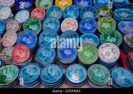 Exposition dans un marché marocain montrant une partie de la poterie en argile. Bols et plats décorés dans des tons verts et bleus Banque D'Images