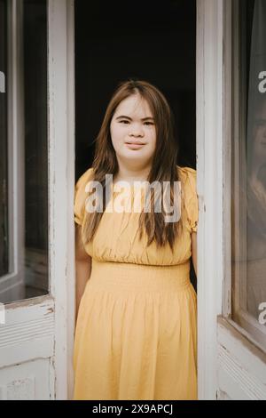 Portrait d'une jeune femme atteinte du syndrome de Down debout à la porte Banque D'Images