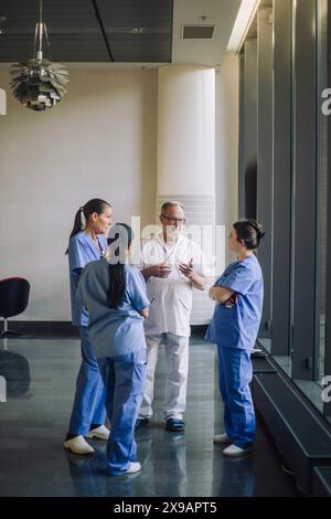Médecins hommes et femmes discutant dans le hall de l'hôpital Banque D'Images