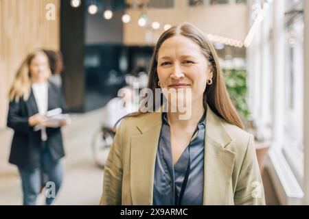 Portrait de femme d'affaires mature souriante debout au centre de congrès Banque D'Images