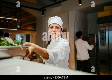 Portrait d'une jeune femme chef travaillant dans la cuisine commerciale Banque D'Images