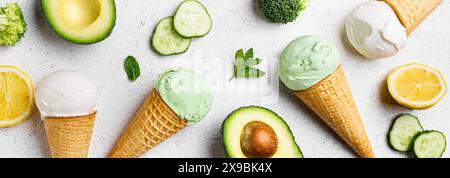 Cuillères à crème glacée avocat vert noix de coco dans des cônes gaufrés, vue de dessus, bannière. Crème glacée végétalienne tendance avec légumes verts. Banque D'Images