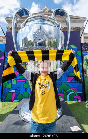 Londres, Royaume-Uni. 30 mai 2024. Loius, 11 ans de Dortmund, à côté d'un trophée géant de la Ligue des Champions alors que les fans assistent au Champions Festival à Trafalgar Square avant la finale de la Ligue des Champions entre le Real Madrid et le FC Dortmund au stade de Wembley le 1er juin. Le Champions League Festival, organisé par l'UEFA et des sponsors corporatifs, se déroule dans plusieurs lieux du centre de Londres, proposant des activités, des prix et, pour certains, une chance de gagner des billets pour la finale elle-même. [Autorisation parentale accordée] crédit : Stephen Chung / Alamy Live News Banque D'Images