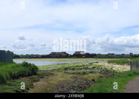 Gosport, Hampshire, Angleterre. 17 mai 2024. Haslar Lake, marée basse, paysage montrant des bâtiments lointains. Banque D'Images