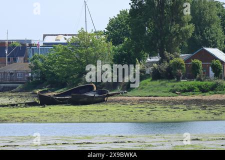 Gosport, Hampshire, Angleterre. 17 mai 2024. Deux petits bateaux, délabrés, sur le rivage à marée basse, Haslar Lake. Banque D'Images