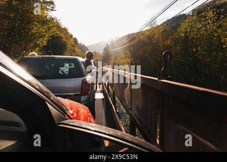 La vue de l'intérieur d'une voiture voyageant sur mororail à travers la campagne en Slovénie. Deux garçons se penchent par la fenêtre de la voiture devant Banque D'Images