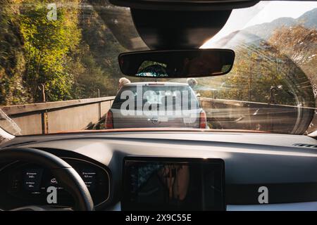 La vue de l'intérieur d'une voiture voyageant sur mororail à travers la campagne en Slovénie. Deux garçons se penchent par la fenêtre de la voiture devant Banque D'Images