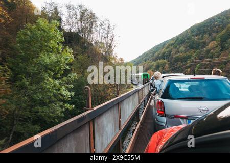 Les jeunes garçons se penchent par la fenêtre d'une voiture alors qu'elle se déplace à l'arrière d'un wagon de train à moteur alors qu'elle traverse des tunnels et des gorges en Slovénie Banque D'Images