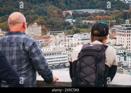 Les touristes se tiennent au sommet d'une tour de guet au château de Ljubljana, Slovénie, regardant la ville, par temps nuageux Banque D'Images