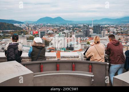 Les touristes se tiennent au sommet d'une tour de guet au château de Ljubljana, Slovénie, regardant la ville, par temps nuageux Banque D'Images