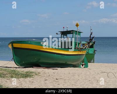 Deux bateaux de pêche verts et jaunes debout près de la mer sur une plage de sable, des bateaux de pêche verts et jaunes sur la plage en Pologne, sopot, pologne Banque D'Images