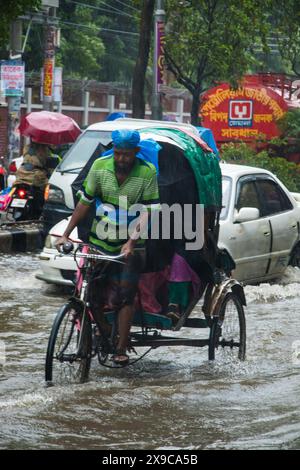 Le cyclone Remal a provoqué de fortes précipitations, des inondations et des vents violents dans la ville de Dacca, entraînant des perturbations dans les transports, des coupures de courant et d’importantes propriétés Banque D'Images