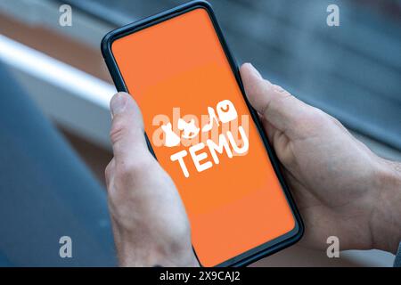 30 mai 2024 : téléphone portable ou smartphone dans la main d'une personne qui ouvre l'application shopping ou la plate-forme Temu du groupe numérique chinois PDD sur Internet et le logo apparaît. PHOTOMONTAGE *** pratique bzw. Smartphone in der hand einer person, welche mobil im Internet die Shopping-App bzw. Plattform Temu des chinesischen Digitalkonzern PDD öffnet und das logo erscheint. FOTOMONTAGE Banque D'Images