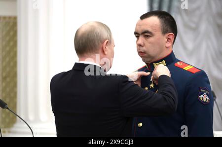 Moscou, Russie. 30 mai 2024. Le président russe Vladimir Poutine, à gauche, présente le sergent junior Albert Zainullin, à droite, le héros de la Russie lors d'une cérémonie de remise des prix à la salle Sainte-Catherine du Palais du Kremlin, le 30 mai 2024, à Moscou, en Russie. Crédit : Vyacheslav Prokofyev/Kremlin Pool/Alamy Live News Banque D'Images