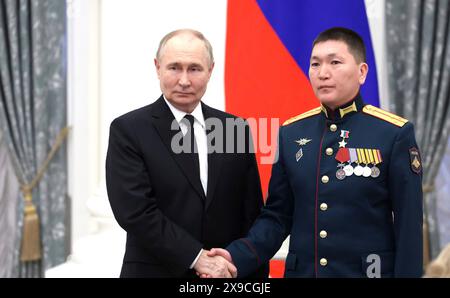 Moscou, Russie. 30 mai 2024. Le président russe Vladimir Poutine, à gauche, présente le premier lieutenant Chalym Chuldum-ool, à droite, le héros de la Russie lors d'une cérémonie de remise des prix à la salle Sainte-Catherine du Palais du Kremlin, le 30 mai 2024, à Moscou, en Russie. Crédit : Vyacheslav Prokofyev/Kremlin Pool/Alamy Live News Banque D'Images