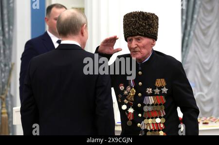 Moscou, Russie. 30 mai 2024. Le vétéran de la seconde Guerre mondiale Ibragim-Pacha Sadykov, à droite, salue le président russe Vladimir Poutine, à gauche, alors qu'il est présenté avec le héros de la Russie lors d'une cérémonie de remise des prix à la salle Sainte-Catherine du Palais du Kremlin, le 30 mai 2024, à Moscou, en Russie. Crédit : Vyacheslav Prokofyev/Kremlin Pool/Alamy Live News Banque D'Images