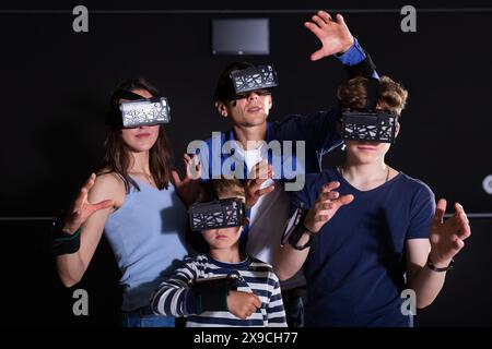 Une famille joyeuse dans des lunettes vr jouant à des jeux ensemble Banque D'Images