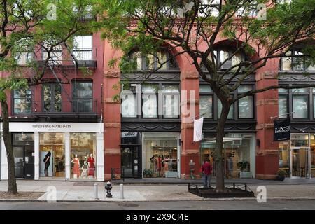 Rangée de boutiques de mode sur une rue bordée d'arbres dans le quartier Soho de Manhattan Banque D'Images