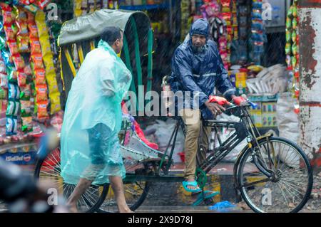 Piétons naviguant dans les rues inondées de Sylhet en raison du cyclone Remal. Ces derniers jours, de fortes pluies ont prévalu dans tout le pays et les zones côtières ont subi des dégâts considérables. Sylhet, Bangladesh. Banque D'Images