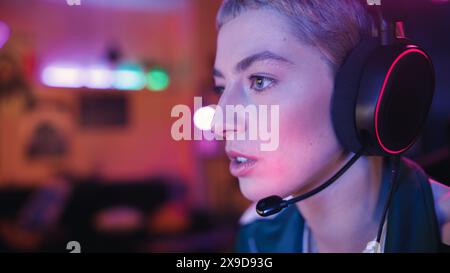 Portrait de Confidence Focused Female Gamer jouant un jeu vidéo dans lequel les joueurs combattent dans un tournoi, elle utilise son puissant ordinateur personnel élégant jeune femme Empowered Banque D'Images