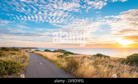 O'Sullivan Beach piste cyclable le long du rivage avec des nuages au-dessus de la mer pendant le coucher du soleil, Australie méridionale Banque D'Images