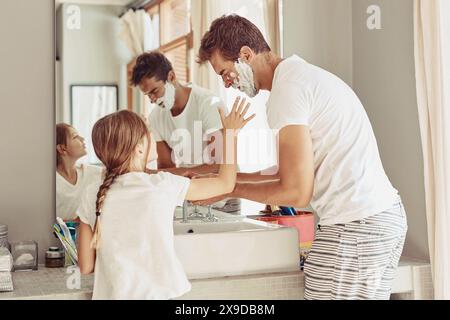 Père, famille et enfant dans la salle de bain rasage avec mousse, crème ou nettoyage du visage à la maison enseignement et liaison. Papa, homme ou parent avec enfant pour Banque D'Images