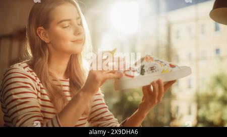 Designer de mode féminin plein d'idées et de création de design pour paire de baskets usagées. Artiste adolescent regardant un ordinateur portable et dessinant sur des chaussures. Fait sur mesure et concept de vêtements respectueux de l'environnement. Banque D'Images