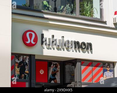 Logo Lululemon Athletica signe sur un bâtiment de magasin de rue. Le détaillant canadien de vêtements de sport possède une marque de mode populaire et offre des vêtements. Banque D'Images