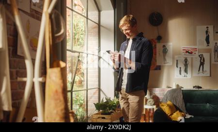 Homme caucasien utilisant smartphone tout en se reposant à la maison. Happy Male Blogger créer du contenu drôle et discuter avec les abonnés sur Internet. Concept d'utilisation des réseaux sociaux. Banque D'Images