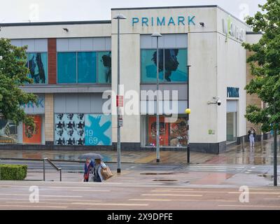 Boutique PRIMARK au centre-ville de Corby par temps pluvieux. Banque D'Images