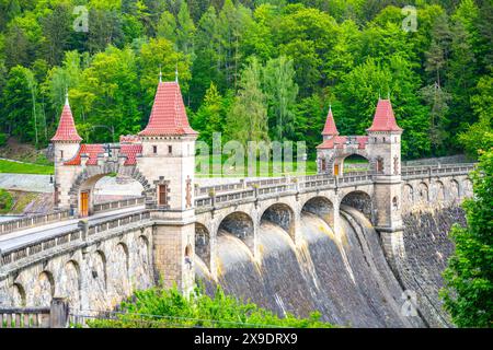 Une vue sur le barrage les Kralovstvi en Tchéquie, mettant en valeur l'arche complexe et la maçonnerie de la structure. Le barrage est haut et imposant, entouré de verdure luxuriante. Banque D'Images