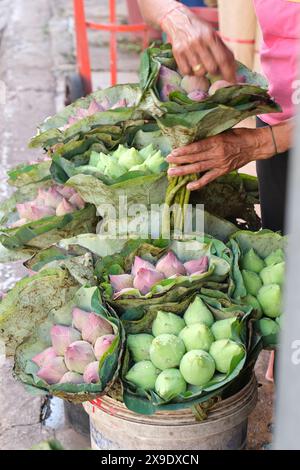 Un vendeur organise des fleurs dans un marché aux fleurs à Bangkok. Banque D'Images