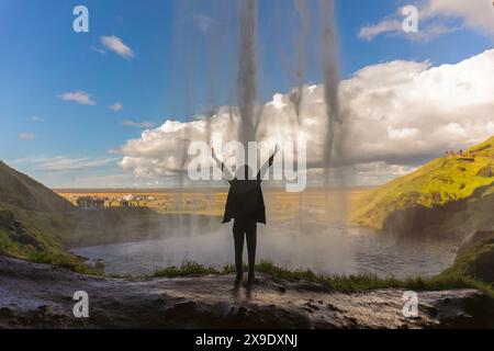 Femme apprécie la vue de Seljalandsfoss Waterfall en Islande. Banque D'Images