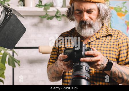 Photographe en studio examinant les prises de vue Banque D'Images