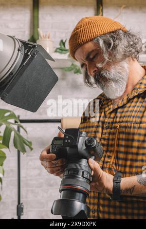 Photographe en studio examinant les prises de vue Banque D'Images