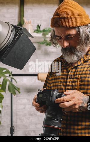 Photographe en studio examinant les prises de vue Banque D'Images